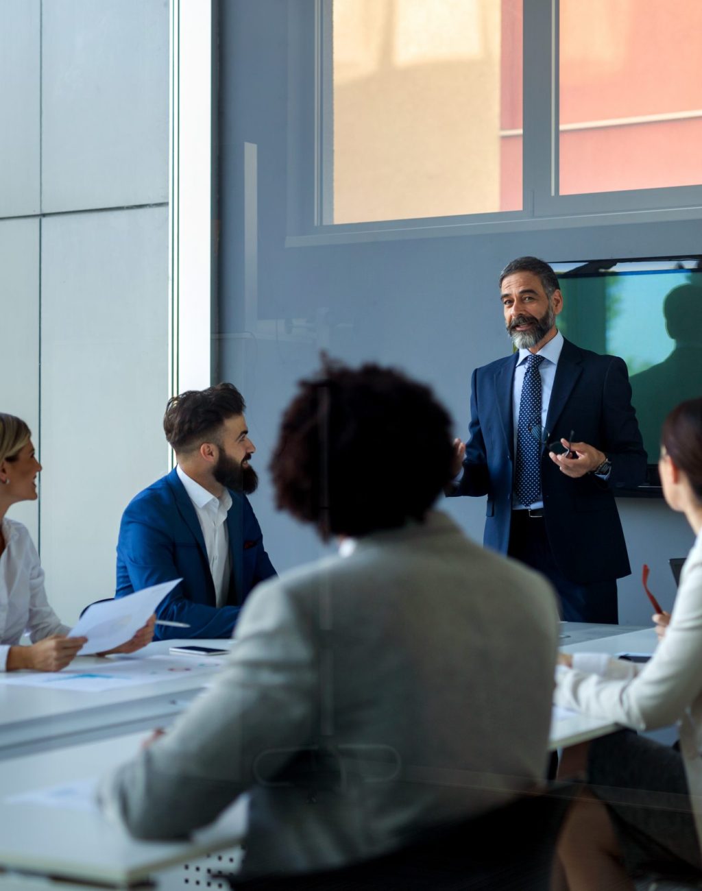 Business team working together on meeting, analyzing financial documents in office Diverse business team working together on meeting, analyzing financial documents in office